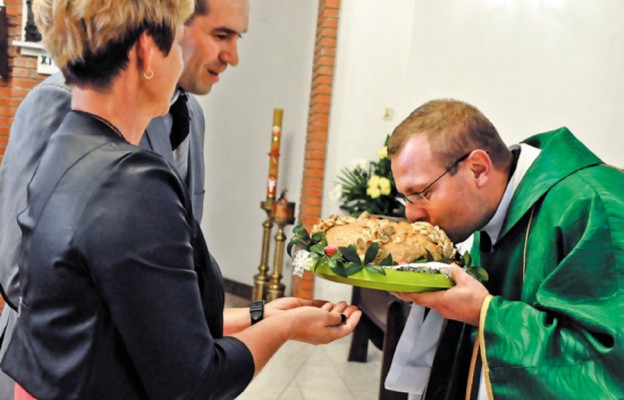 Ks. Tadeusz Solski odbiera chleb od starostów dożynek