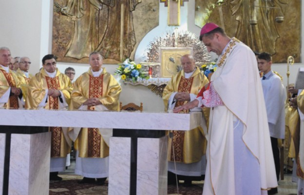 Biskup namaszcza ołtarz poświęconym olejem