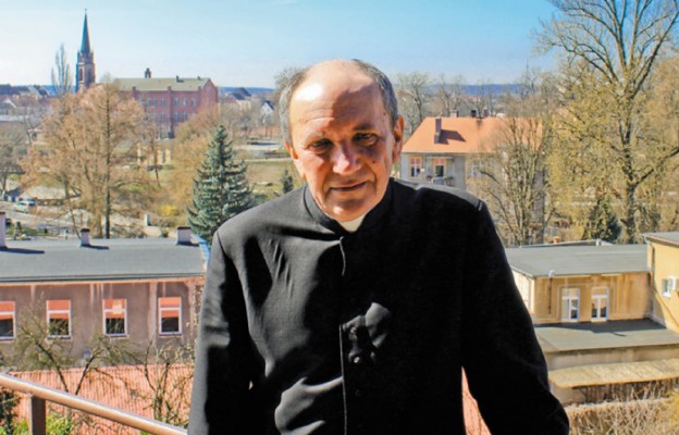 Ks. Ryszard Rudkiewicz, proboszcz parafii pw. Trójcy Świętej w Gubinie. W tle kościół ewangelicki Klosterkirche w Guben