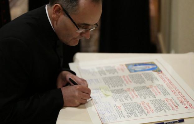 Akt podpisuje najmłodszy stażem w Episkopacie biskup nominat Andrzej Przybylski