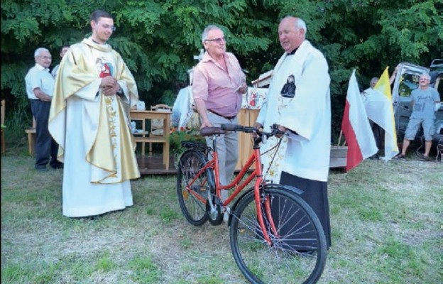 Marian Miś odbiera nagrodę z rąk proboszcza ks. Edwarda Białasa