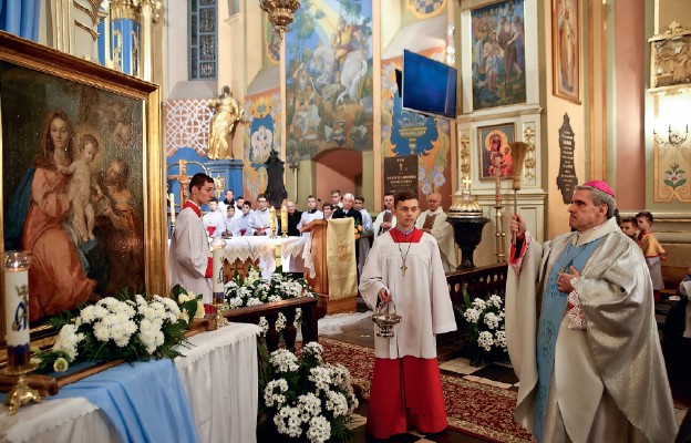 Biskup poświęca obraz Świętej Rodziny, na którym Pan Jezus trzyma jabłko