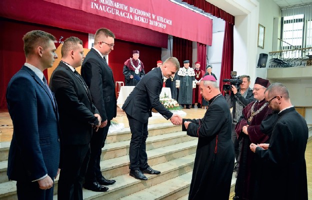 Biskup Jan Piotrowski wręcza indeksy nowym studentom