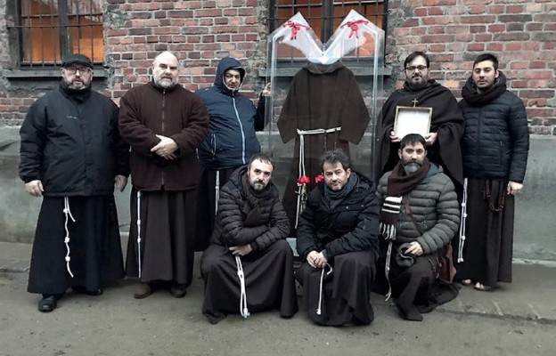 Ojcowie z relikwiami o. Pio przy celi św. Maksymiliana w muzeum Auschwitz