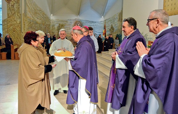 Przedstawiciele parafii wręczają biskupowi Janowi chleb