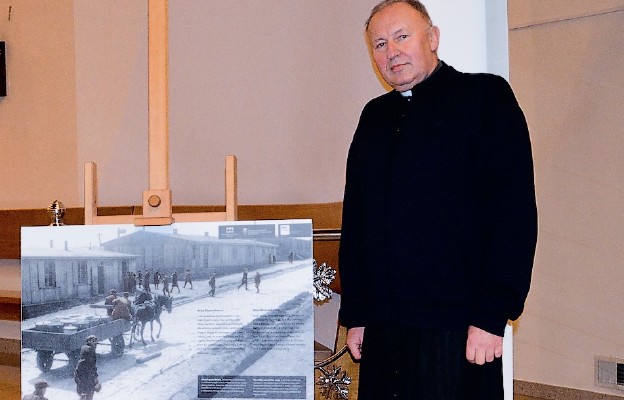 Ks. Jacek Konieczny w kościele św. Kingi, przy fotografii tablicy przypominającej o cierpieniu więźniów obozu w Płaszowie