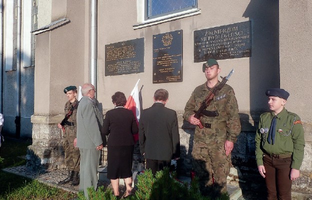 Złożenie kwiatów przed tablicą pamięci