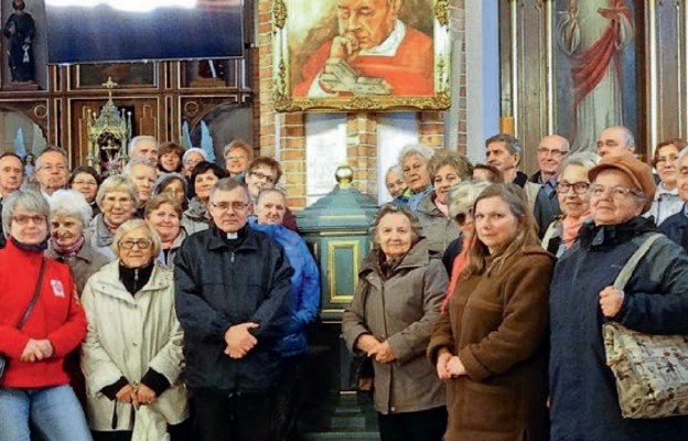 Uczestnicy pielgrzymki przy chrzcielnicy Prymasa Tysiąclecia