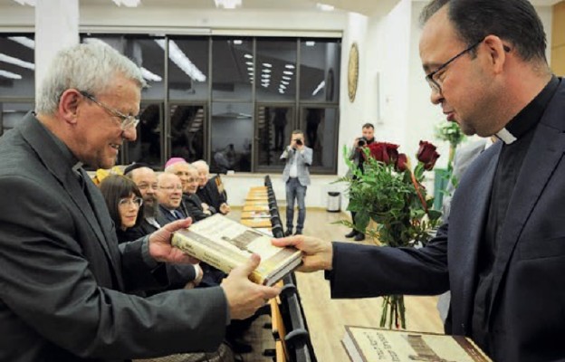 Ks. Marek Szymański, dyrektor „Gaudium”, przekazuje egzemplarz Biblii ks. prof. Antoniemu Troninie