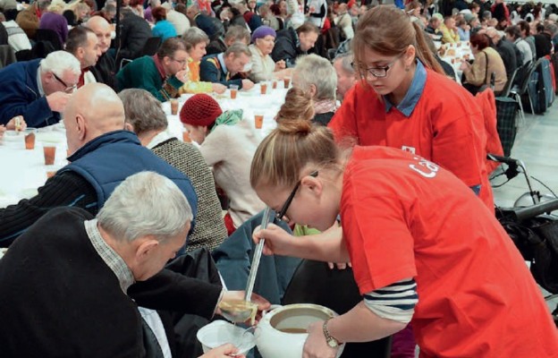 Wolontariusze Caritas pomagają przy wydawaniu posiłków