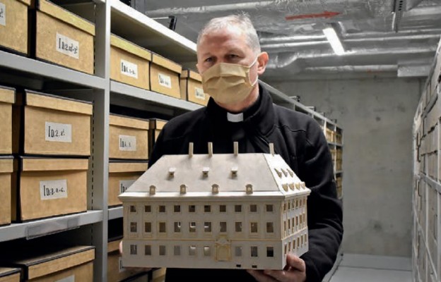 Ks. Adam Dereń, koordynator budowy, z modelem Biblioteki