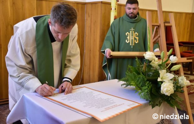 Ks. Wojciech Gaura podpisuje akt przyjęcia Jezusa jako Zbawiciela i Pana wspólnoty parafialnej