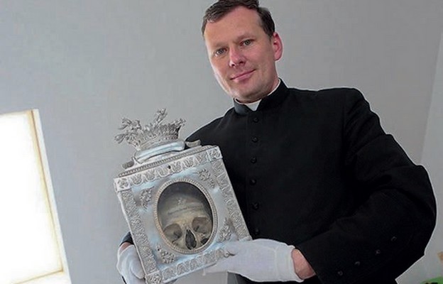 Ks. Marek Wojnarowski pokazuje jedną z czaszek towarzyszek św. Urszuli
