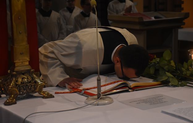 Diakon Marcin Wachowicz całujący księgę Ewangelii