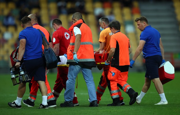 Zawodnik Rakowa Częstochowa Wiktor Długosz (C) znoszony z boiska po kontuzji głowy podczas pierwszego meczu 4. rundy eliminacji piłkarskiej Ligi Konferencji z KAA Gent