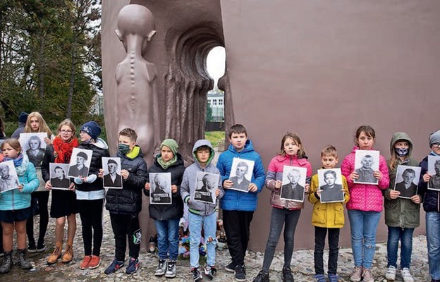 Dzieci trzymające zdjęcia ofiar „małego Auschwitz”