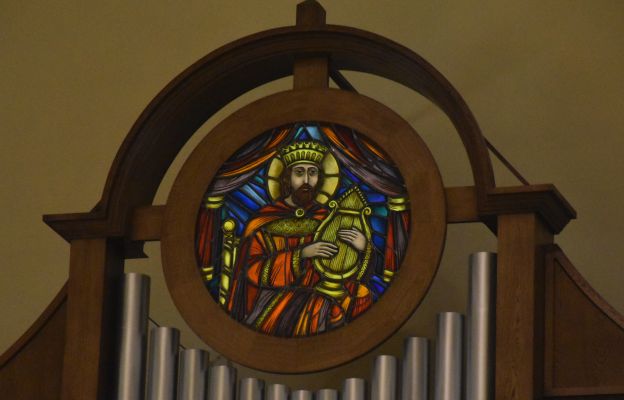Na szczycie szafy organowej znajduje się witraż z wizerunkiem króla Dawida grającego na harfie