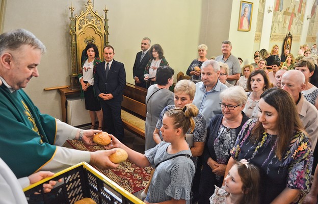 Proboszcz ks. Janusz Marzec wręczył chlebki uczestnikom Eucharystii