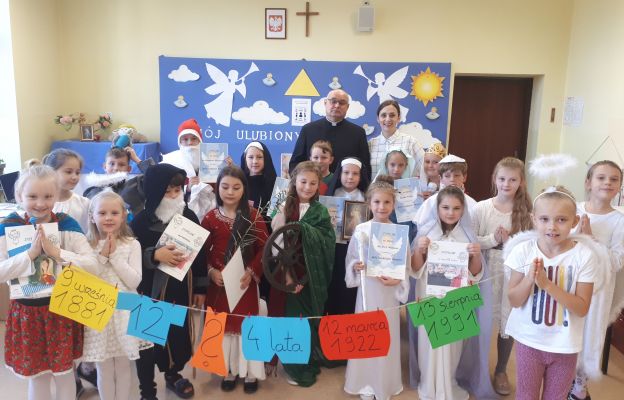 Uczestnicy szkolnego konkursu o świętych wraz z katechetką i ks. proboszczem Markiem Mielczarkiem 