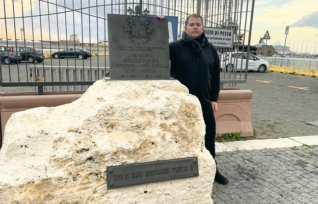 Alessandro Scotto przy obelisku stojącym przy wejściu na molo św. Jana Pawła II w Civitavecchia