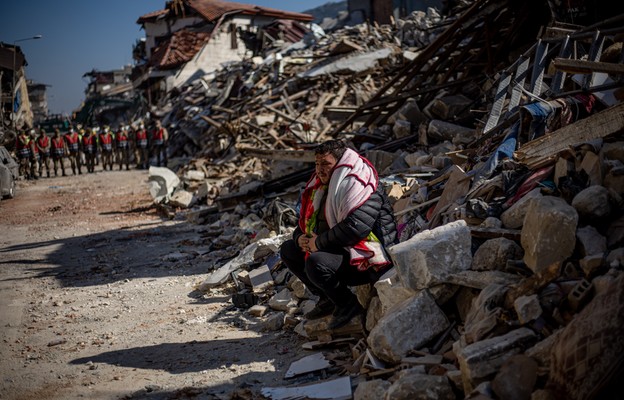 Mężczyzna siedzi na gruzach zawalonych budynków po silnym trzęsieniu ziemi, w Hatay, Turcja