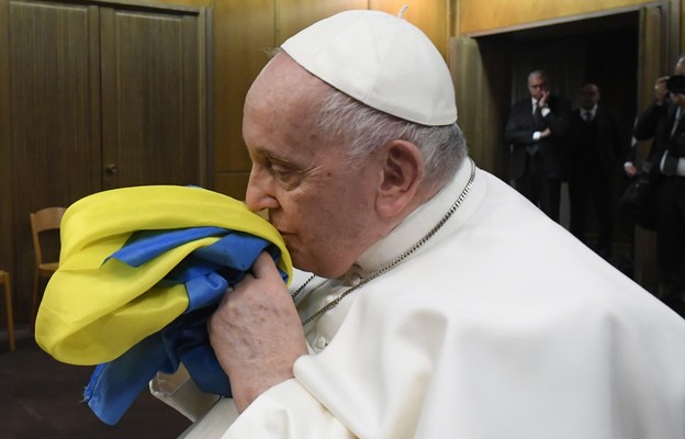 Papież Franciszek całujący flagę narodową Ukrainy podczas projekcji filmu Freedom On Fire: Ukraine's Fight for Freedom, w Watykanie, 24 lutego 2023 r.