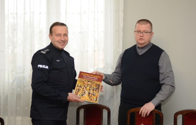 Ks. proboszcz Marcin Gęsikowski wręczył policjantom album o świdnickiej katedrze