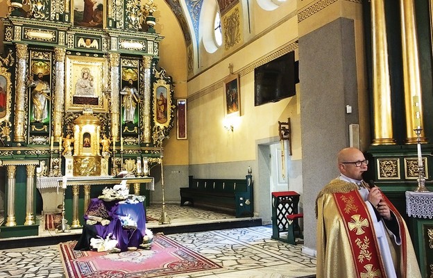 Proboszcz ks. Marek Sendal na tle głównego ołtarza w sączowskim kościele