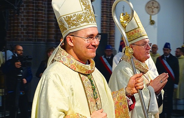 Bp Tomasz Sztajerwald jako zawołanie biskupie obrał słowa: „Umiłował nas”.
Z prawej abp Józef Górzyński