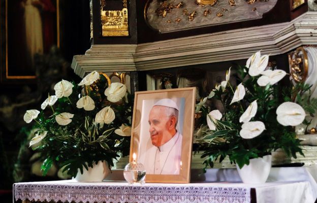 Fotografia papieża Franciszka ustawiona przy ołtarzu w Katedrze Świdnickiej, otoczona kwiatami i płomieniem lampki – znak modlitwy i pamięci o zmarłym Ojcu Świętym